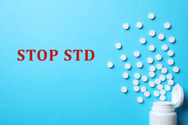 istock Bottle with pills and text STOP STD on light blue background, flat lay 1412226564