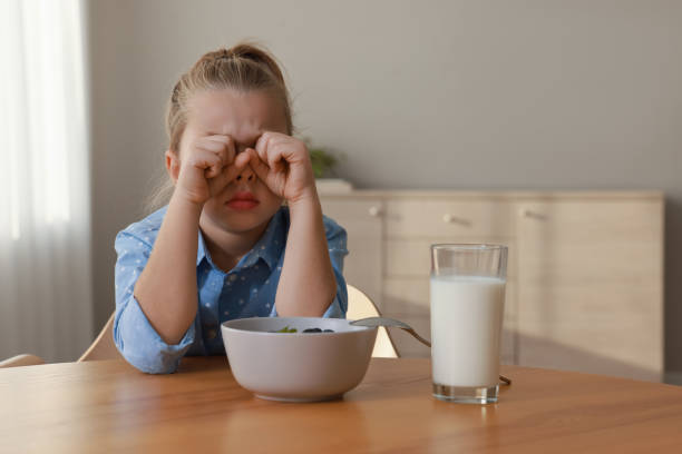 istock Cute little girl crying and refusing to eat breakfast at home 1412226905