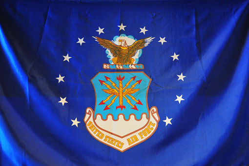 United State Air Force Flag (USAF), Colorado Springs, Colorado, USA - American Air Force Flag - ultramarine blue field with the USAF shield: 13 stars representing the Original Colonies.  The crest includes the American Bald Eagle, symbol of the US and air striking power.  The shield, divided with the nebuly line formation, representing clouds, is charged with the heraldic thunderbolt, portraying striking power.