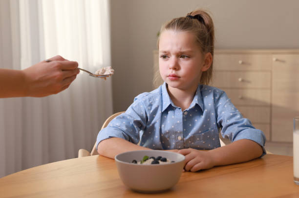 istock Cute little girl refusing to eat her breakfast at home 1412227192