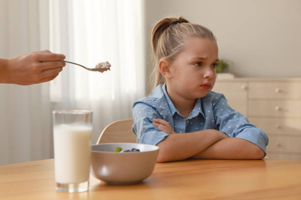 istock Cute little girl refusing to eat her breakfast at home 1412227250