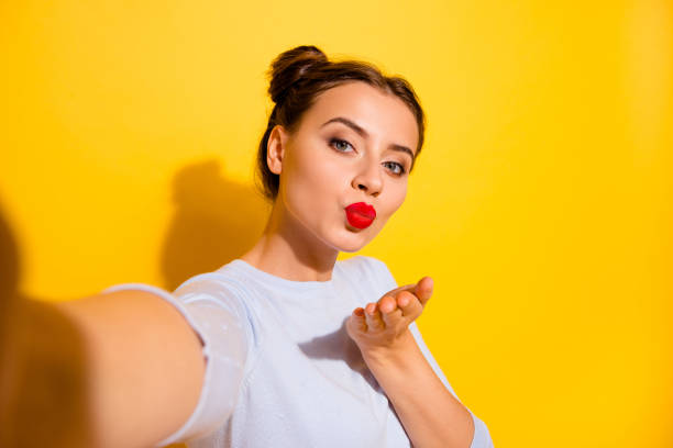 foto de adorable dama brillante usa manga larga grabando auto video enviándote beso de brazo aislado fondo de color amarillo - red lipstick fotografías e imágenes de stock