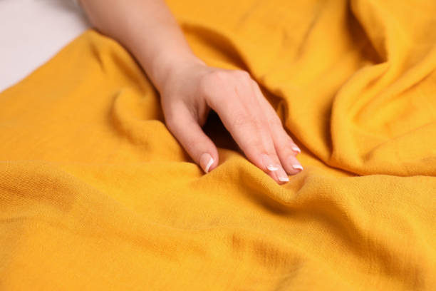 femme touchant un tissu jaune doux, vue rapprochée - yellow color image textured sensory perception photos et images de collection