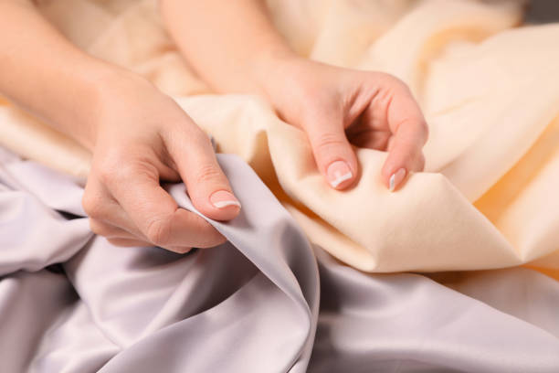 Woman touching different soft fabrics, closeup view