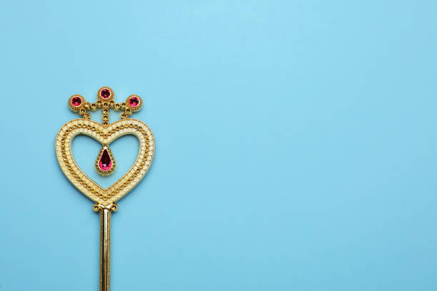 Beautiful golden magic wand on light blue background, top view. Space for text
