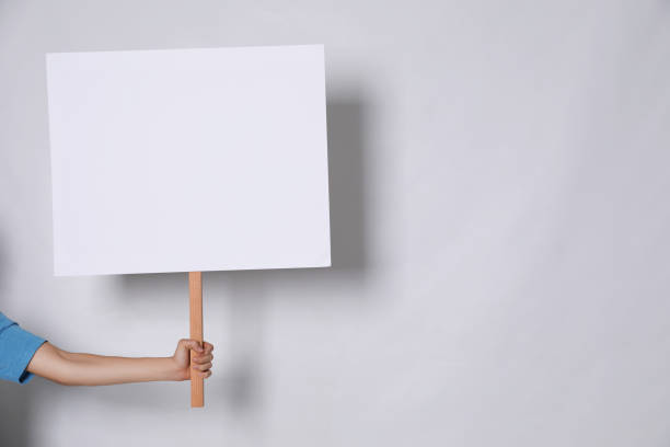istock Woman holding blank sign on light grey background, closeup. Space for text 1412230762