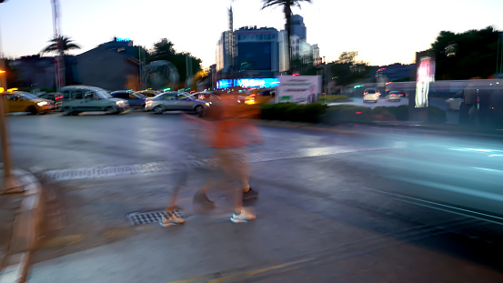 People are crossing the street in a traffic in Alsancak, Izmir, Turkey on July 30, 2022. Photos were taken with long exposure.