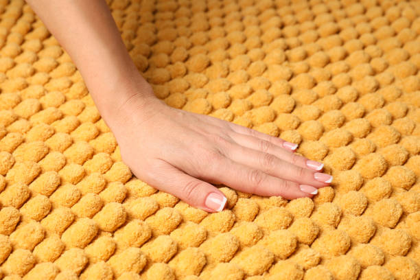 istock Woman touching soft yellow fabric, closeup view 1412231921