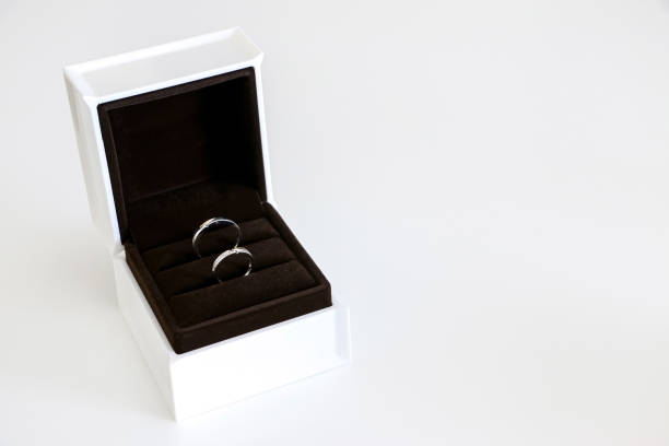 istock Pair of beautiful sparking wedding rings displayed in open box on left side, isolated against white background, concept of romance, love and marriage 1412232067