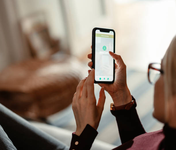 istock An Anonymous Woman Using A Mobile Phone App For Online Banking 1412233586