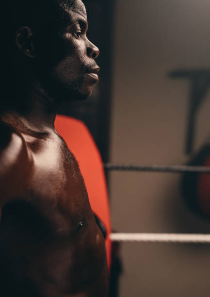 istock Shirtless young boxer standing in a boxing ring 1412233703