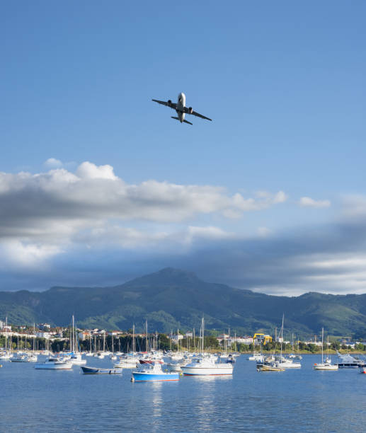 istock Plane flying over the ships and the mountains in the background. 1412234527