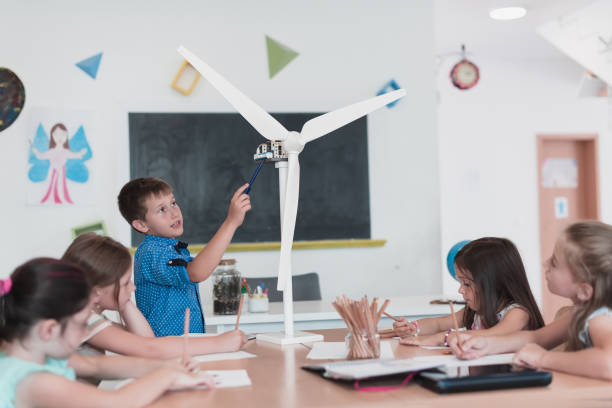 istock Elementary School Stem Robotics Classroom Diverse Group of Children Building and Programming windmill ecology robot concept. Together Talking and Working as a Team. Creative Robotics Engineering 1412244178