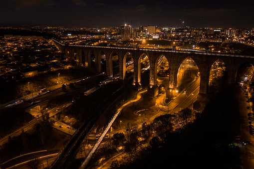 Aqueduto das Águas Livres at night, one of Lisbon’s more distinctive landmarks, with the city in the background.