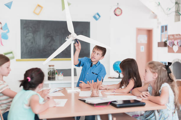 istock Elementary School Stem Robotics Classroom Diverse Group of Children Building and Programming windmill ecology robot concept. Together Talking and Working as a Team. Creative Robotics Engineering 1412244501