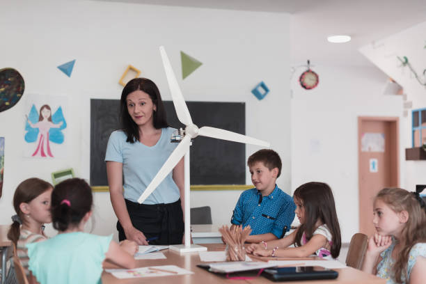 istock Elementary School Stem Robotics Classroom Diverse Group of Children Building and Programming windmill ecology robot concept. Together Talking and Working as a Team. Creative Robotics Engineering 1412245804