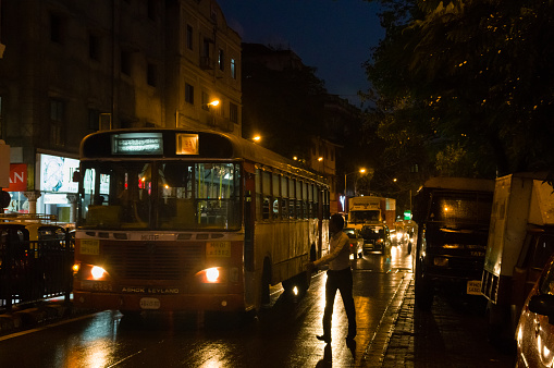 Mumbai, Maharashtra, India  March 1, 2015: Commuter catching a bus at night in Mumbai
