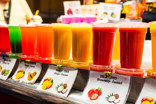 Spain, Barcelona - May 26 2022: Tasty fresh natural fruit juice and smoothies at the Boqueria Market in Barcelona.