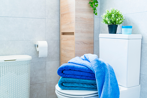 Blue towels placed on a modern bathroom toilet. High resolution 42Mp indoors digital capture taken with SONY A7rII and Zeiss Batis 40mm F2.0 CF lens