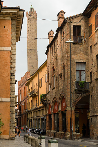 Bologna, Italy  June 25, 2017: Asinelli Tower of the two towers of Bologna seen from narrow street