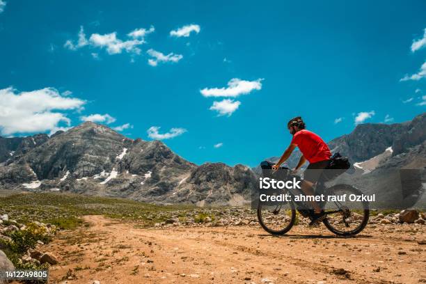 Triangle Less Snowy Imposing Mountain Dirt Road Bike Tour Stock Photo - Download Image Now