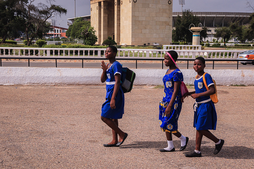 Accra, Ghana - April 06, 2022: Local African Ghana People walking to the daily activities on the Accra Streets