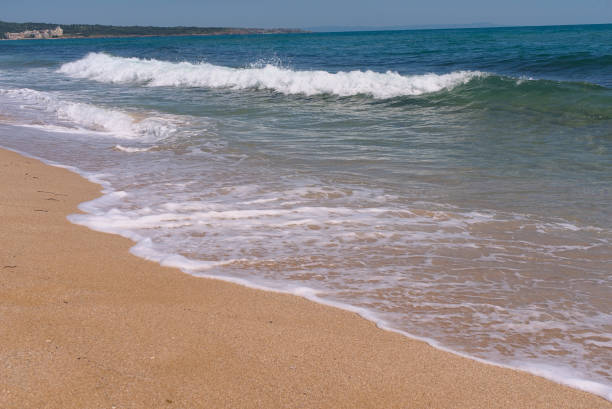istock Clear emerald green sea with white foam and clean sandy beach 1412254300