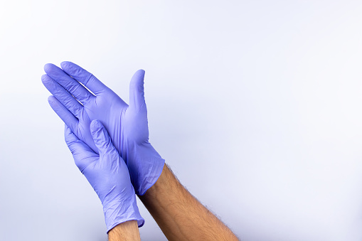 two human hands in blue nitrile surgical gloves, professional medical safety and hygiene for surgery and medical examination on a white background. Lots of empty space