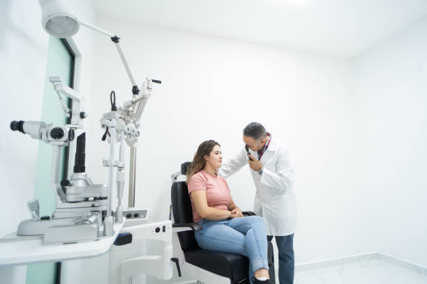 Woman sitting during eye exam next to ophthalmologist
