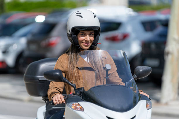 istock Woman with safety helmet riding a motorcycle 1412263286