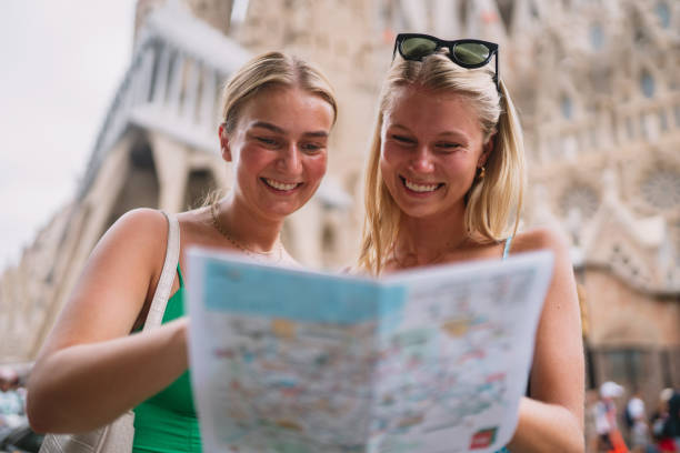 istock Happy friends enjoying her trip in Barcelona holding a map. 1412263379