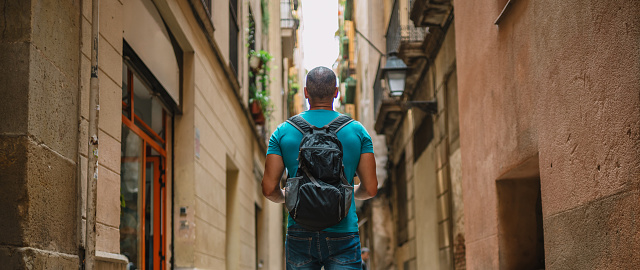Male tourist walking in old town alley. Barcelona, Spain.