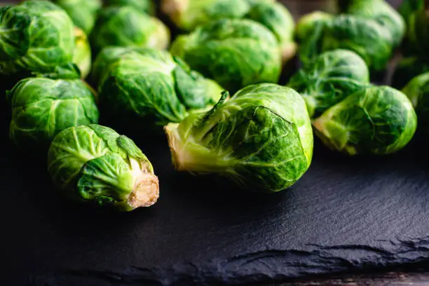 Side view of Brussels sprouts on a rustic slate rock background