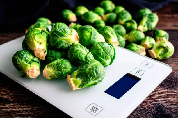 A grouping of organic Brussels sprouts on a kitchen scale