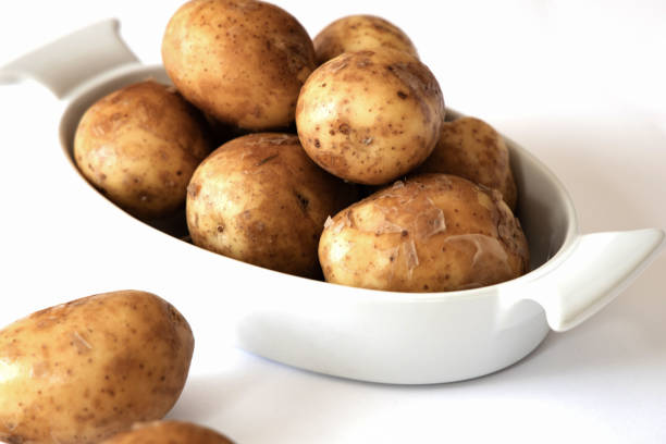 istock Heap of young potatos isolated on white background 1412263797