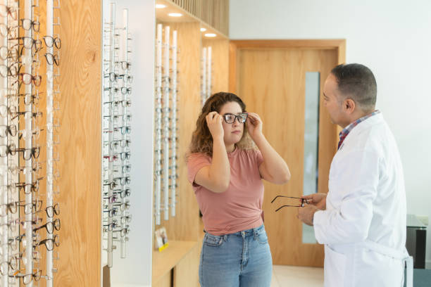 istock Ophthalmologist helping patient to choose eyeglasses 1412264704