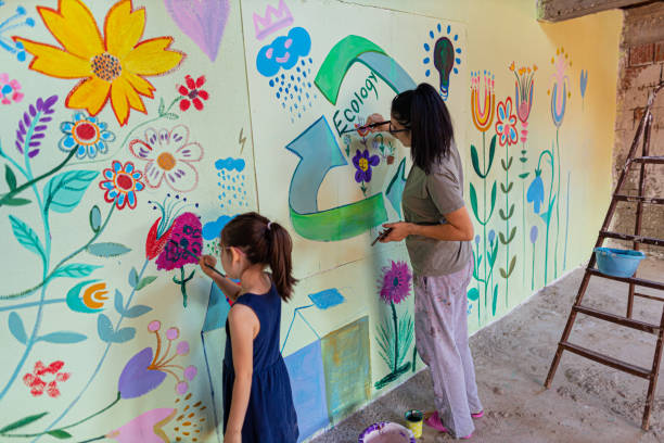 My creative girl Mother and daughter are painting together and having fun. Inspiration mural on the wall fresco stock pictures, royalty-free photos & images