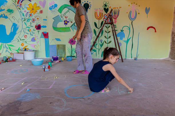 istock Woman drawing with chalk on asphalt with her daughter 1412270643