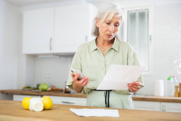 istock Senior woman analyzing bills at home 1412271825