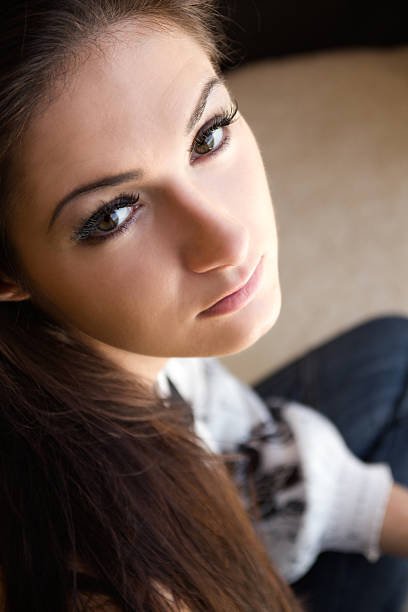 High-resolution close-up of a young woman's face, highlighting her natural beauty, clear skin, and striking eyes.