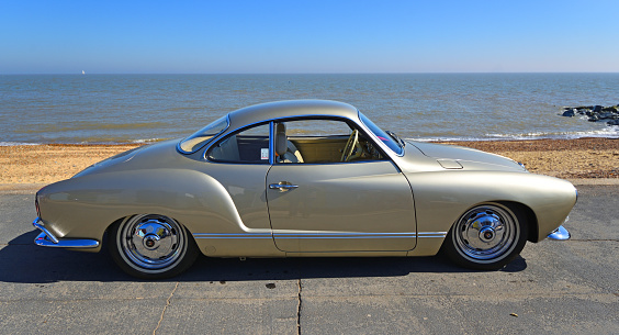 Felixstowe, Suffolk, England -  May 06, 2018: Classic Gold Volkswagen Karmann Ghia parked on seafront promenade.