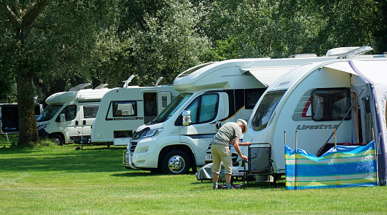 St Neots, Cambridgeshire, England - July 22, 2021: Camper  Vans on  Camp site among trees.