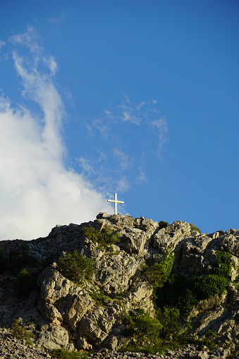 Shining cross in the dark, in front of a beautiful sunset.