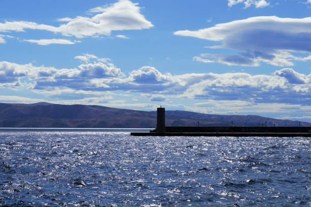 istock Shiny seascape with sparkling sea surface in front of breakwater 1412287328