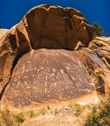 Neolithic graffiti art on a stand-alone rock in the desert