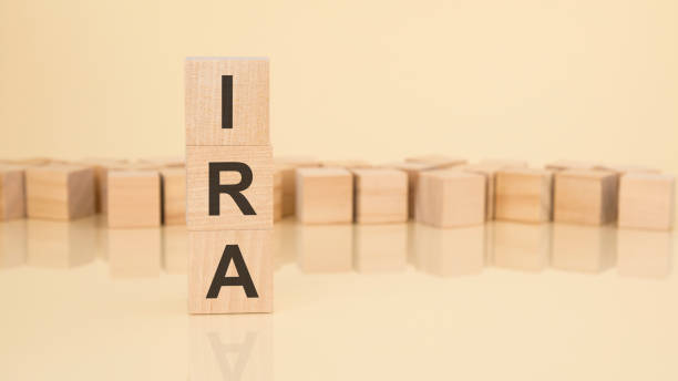 ira pay income tax - acronym from wooden blocks with letters, Individual Retirement Account concept on yellow background. copy space available IRA - acronym from wooden blocks with letters, Individual Retirement Account concept on yellow background. copy space available. ira stock pictures, royalty-free photos & images