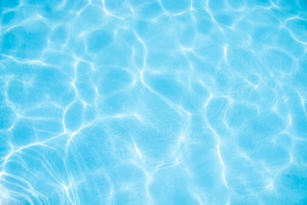 ripples of water in a pool with a blue background stock photo