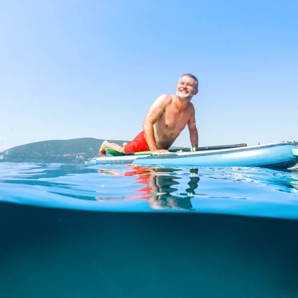 istock Mature man on a paddleboard on the sea 1412301773