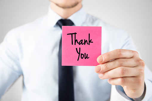 Businessman is holding a card with the Thank you note