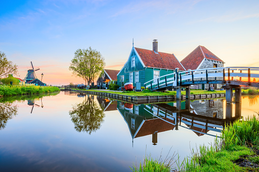 April 21, 2022:  Schans village, Netherlands. Dutch windmill and traditional house at sunrise.
